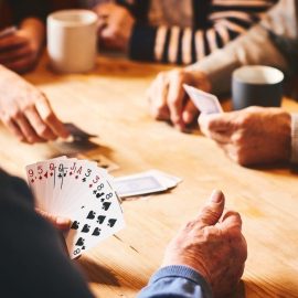 A group of players playing a card game while drinking coffee