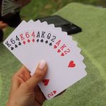 Imagine of a bridge hand with 13 cards, set against a green background. For an article titled How Stablecoins Can Streamline Bridge Tournaments