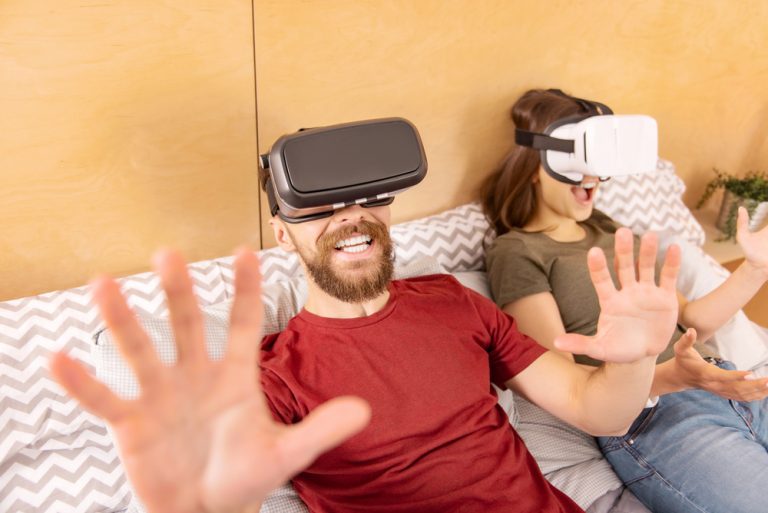Photo of two people wearing VR headsets looking like they are playing a game and enjoying it - Exploring the Future of Online Slots with Virtual and Augmented Reality