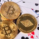 crypto coins piled on top a spread of playing cards - What Are the Most Common Bonus Types at Crypto Casinos?