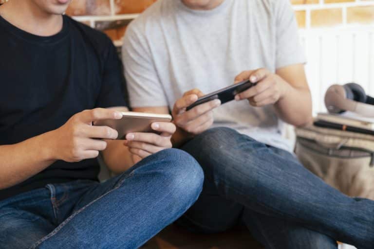 Young men playing casino games on their mobile devices