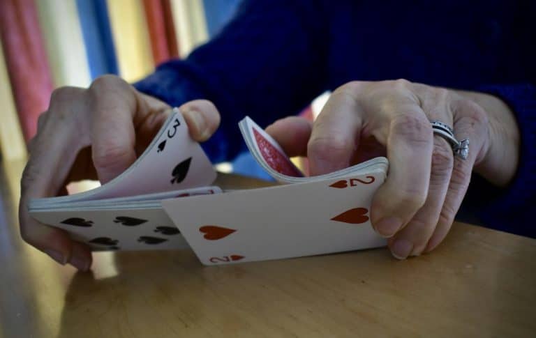 A closeup of hands shuffling a deck of cards