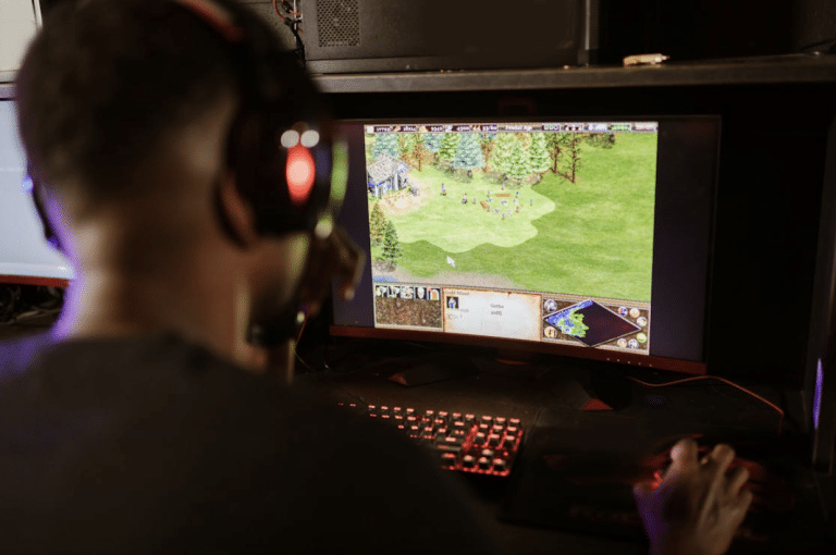A man wearing headset looking at gaming screen